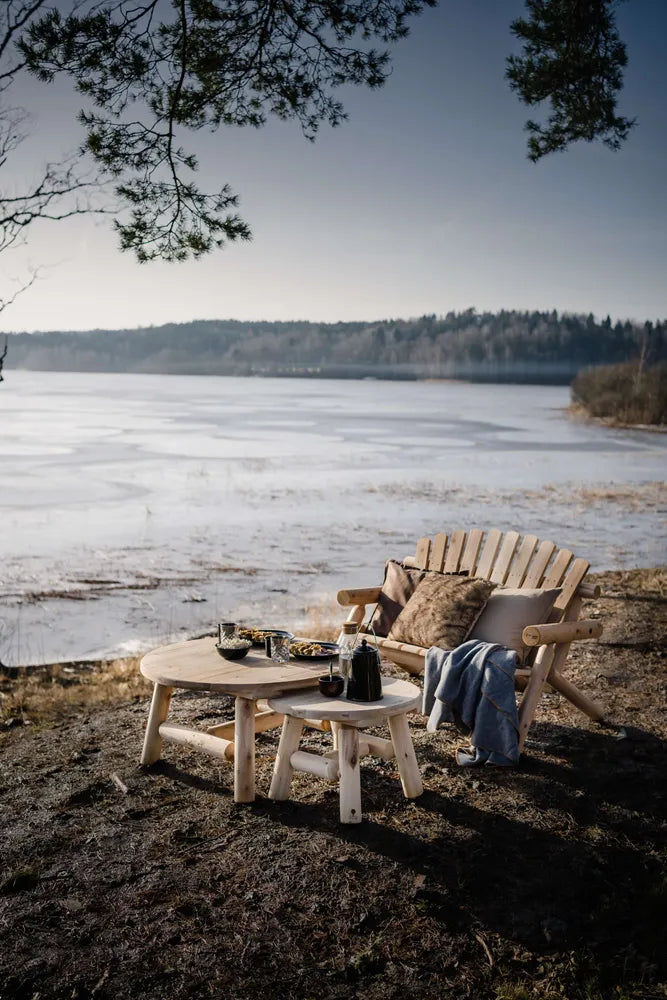 Canadian Outdoor Log Sidebord med flere log møbler på en strand i skumringen