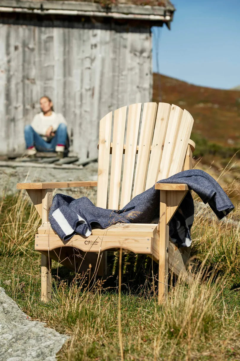 Adirondack stol i fellseter miljø med et blått teppe på