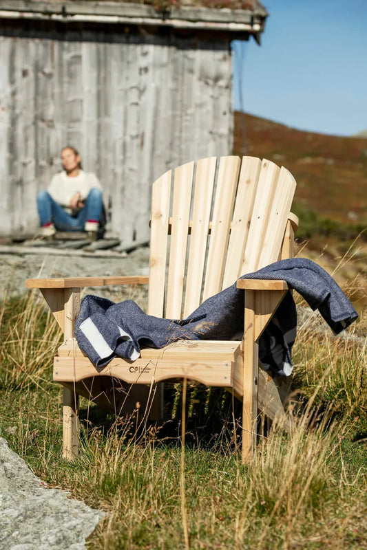 Adirondack stol i fellseter miljø med et blått teppe på