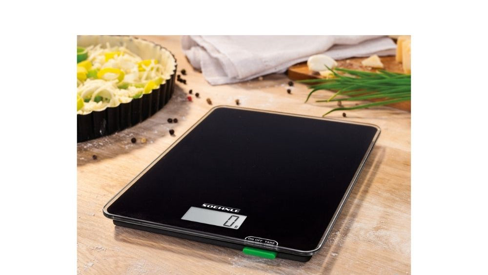 sort kjøkkenvekt plassert i miljø på en kjøkkenbenk